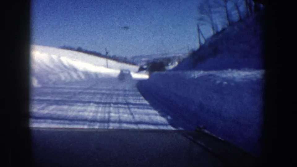 The in-car view continues along a snow-covered Aspen road, with plowed banks, tire tracks, and winter hills ahead.