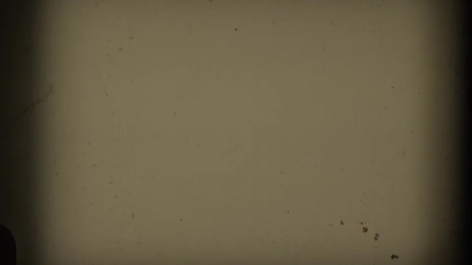 End frame showing blank, dusty 8mm film leader with soft yellow-gray exposure and dark vertical edges.