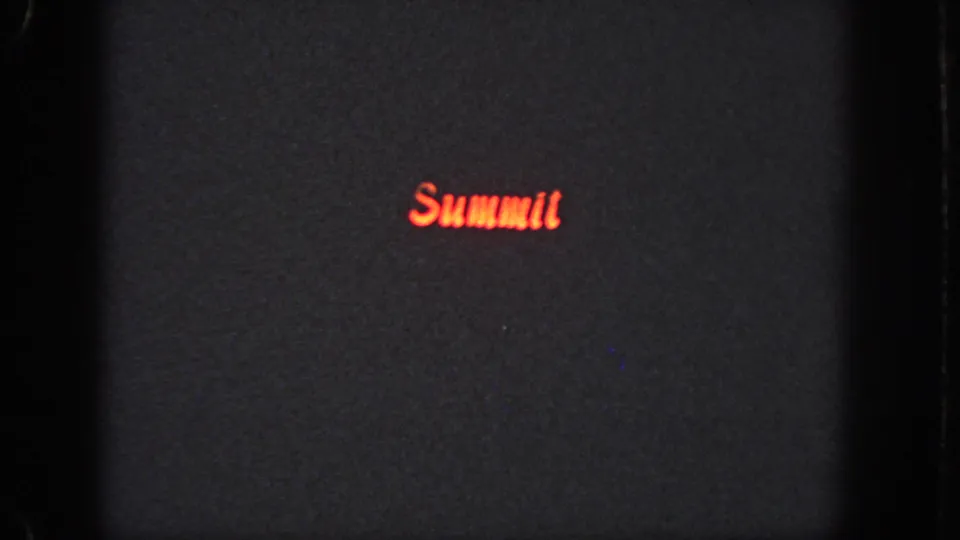 Dark 1951 Atlanta 8mm frame showing a red glowing “Summit” title or sign on a mostly black field.