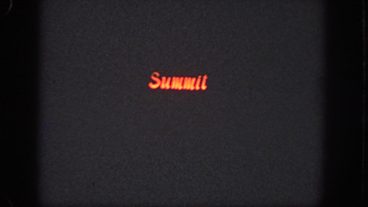 Dark 1951 Atlanta 8mm frame with red “Summit” lettering glowing near the lower center of the projected field.