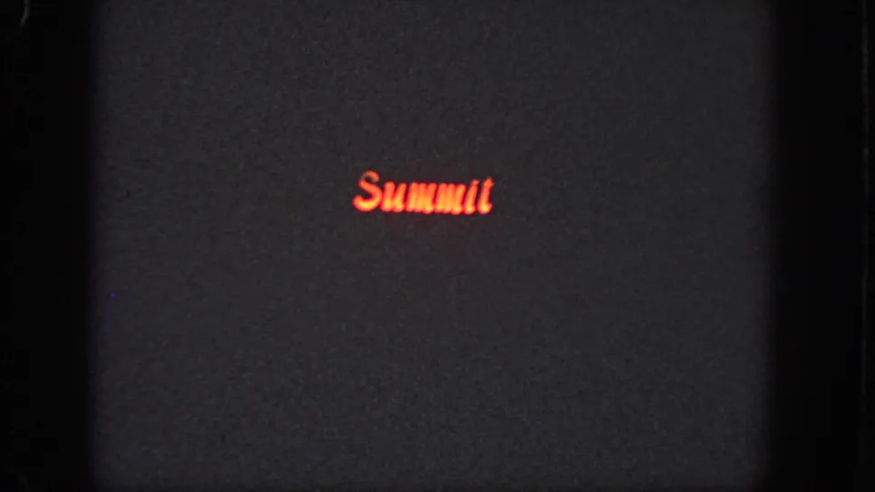 Dark 1951 Atlanta 8mm frame with red “Summit” lettering glowing near the lower center of the projected field.