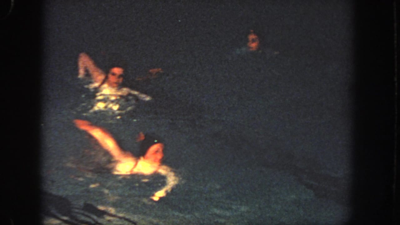 1951 Atlanta 8mm frame showing swimmers in motion at night, including a raised arm and bright reflections on the water.