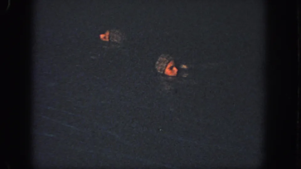 1951 Atlanta 8mm frame showing swimmers partly submerged, with one face catching warm light in the pool.