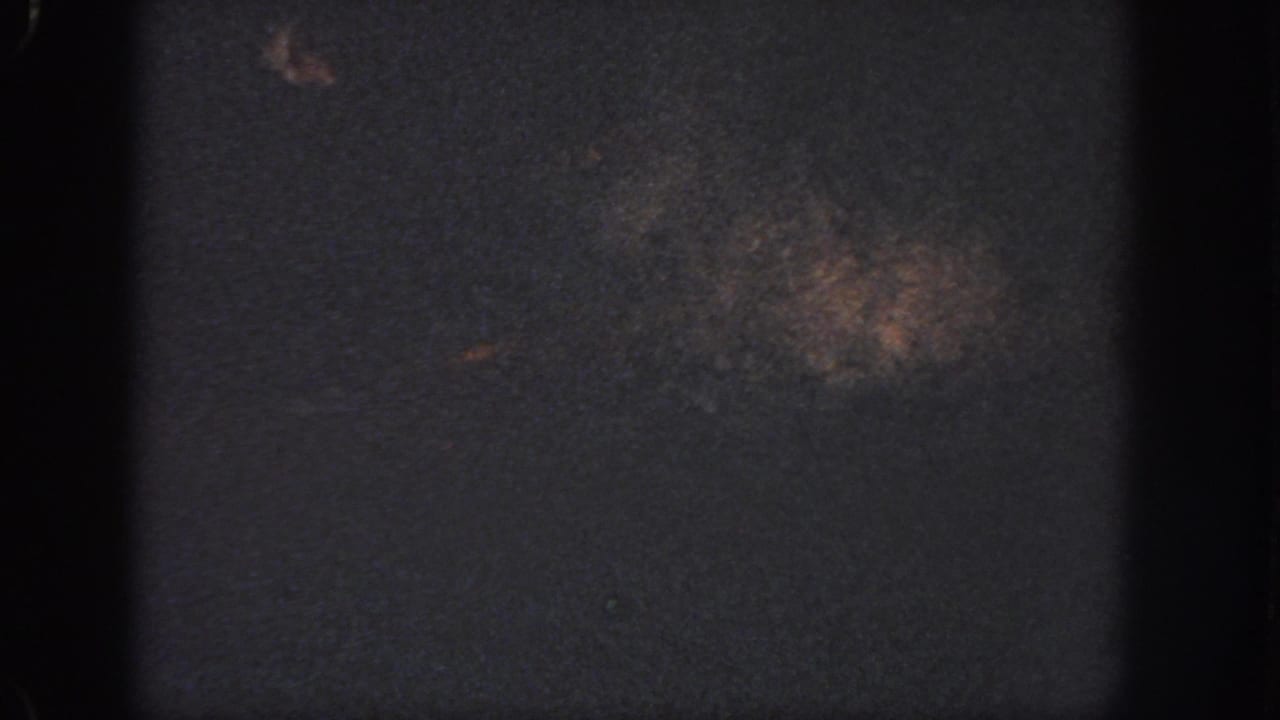 Dark underexposed pool surface with heavy film borders and faint marks.