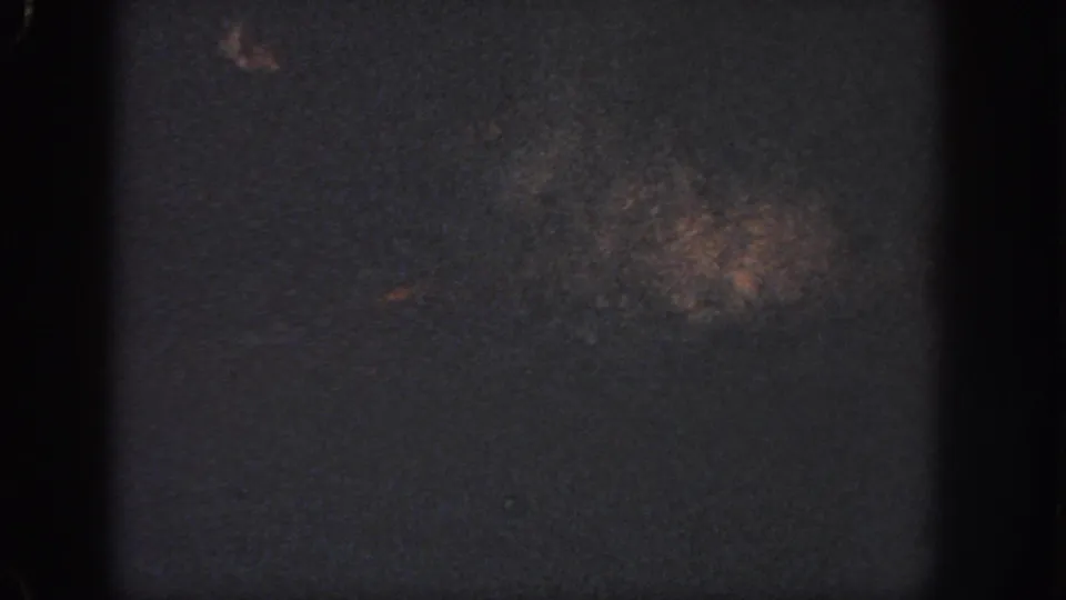 Underexposed 1951 Atlanta 8mm frame showing a dark pool-like surface with gate edges and faint film marks.