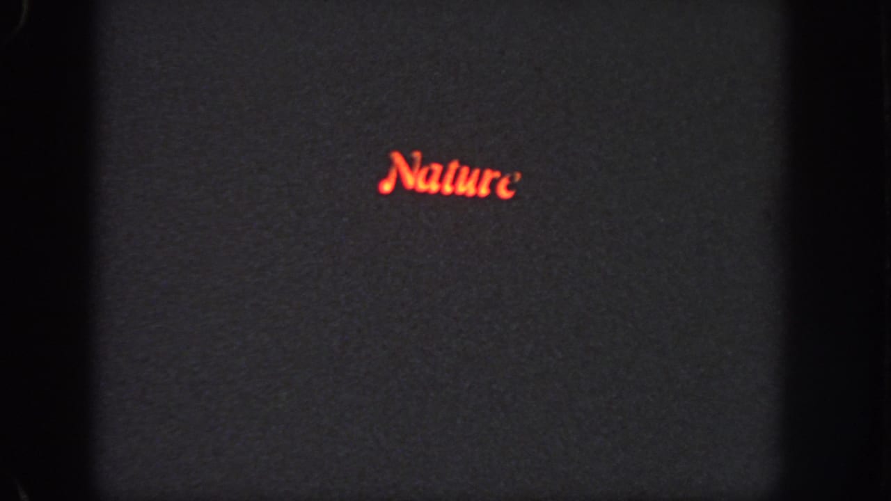 1951 Atlanta 8mm frame with red cursive Nature lettering on a dark projected screen, bordered by visible film gate edges.
