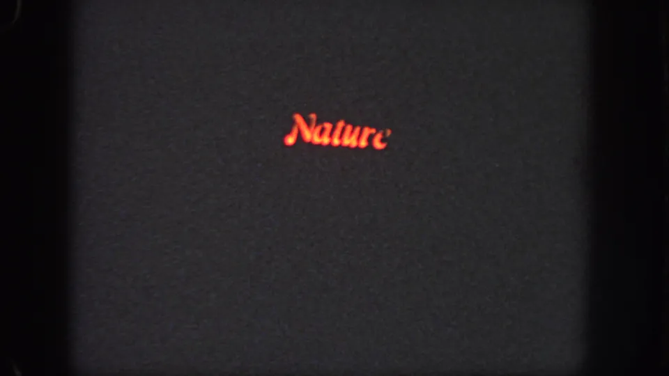 1951 Atlanta 8mm frame with red cursive Nature lettering on a dark projected screen, bordered by visible film gate edges.