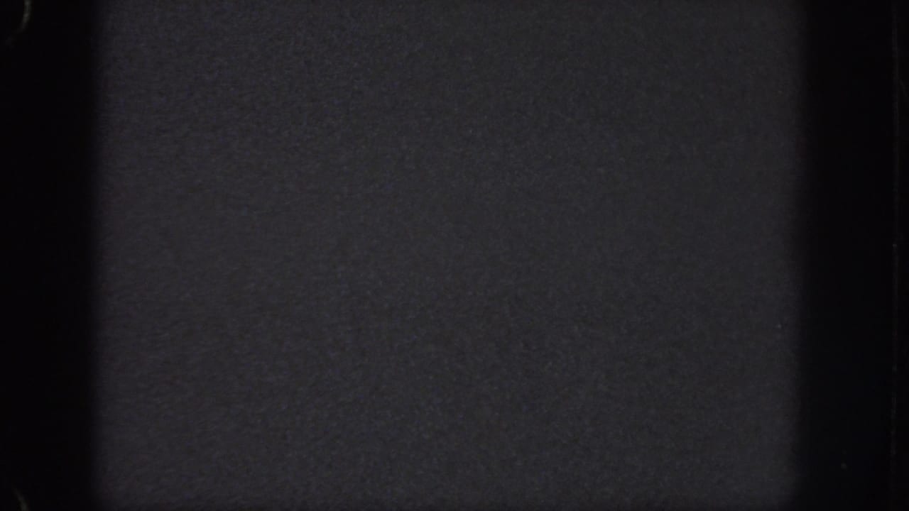Atlanta 1951 8mm frame showing a nearly black night view with visible gate edges and only faint surface detail.