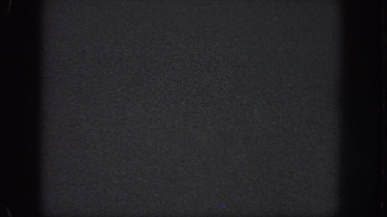 Atlanta 1951 8mm night frame with soft grain, black film borders, and indistinct dark surface detail.