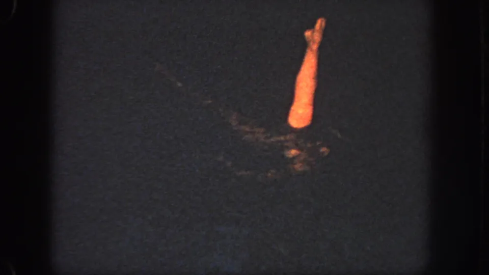 1951 Atlanta 8mm frame showing a swimmer partly submerged, with one illuminated limb raised above rippling dark water.