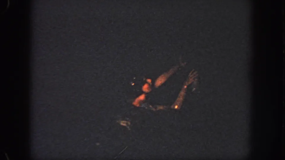 1951 Atlanta 8mm frame of a swimmer in low light, with arms and face area faintly visible above the water.