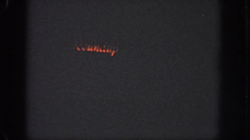 1951 Atlanta 8mm frame with a short red-orange light trail crossing a dark nighttime field.