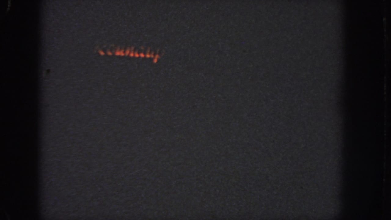 1951 Atlanta 8mm frame showing a small red-orange holiday light pattern low in the dark frame.