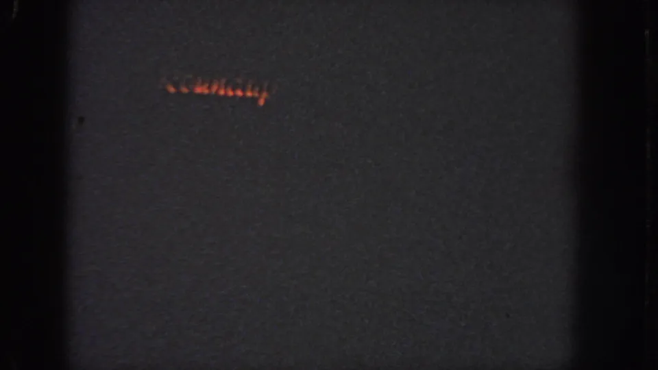 1951 Atlanta 8mm frame showing a small red-orange holiday light pattern low in the dark frame.