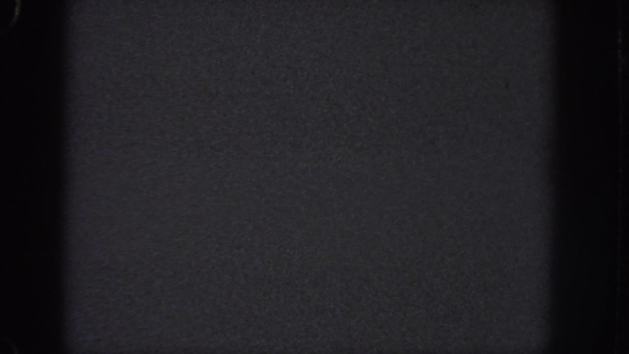1951 Atlanta 8mm frame dominated by darkness, a central black band, soft grain, and faint exposure variation across the film.
