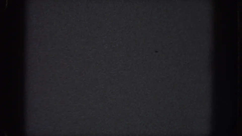 Dark blank 8mm frame from the 1951 Atlanta reel, showing grain, black gate edges, and faint surface specks.