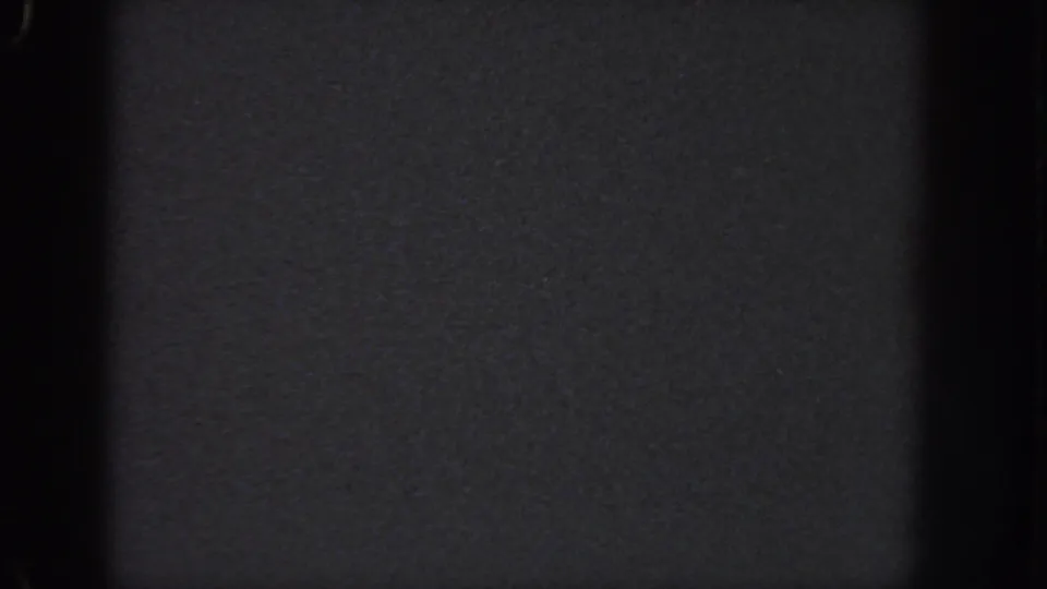 Near-blank 8mm frame from the Atlanta 1951 source, with dark grey texture, dust specks, and black vertical gate edges.