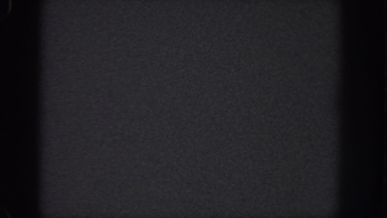 Dark 8mm home-movie frame from the 1951 Atlanta metadata, showing blank film texture, frame edges, and slight banding.