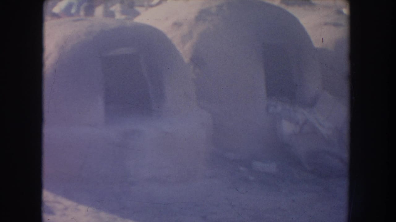 Close view of rounded adobe structures with dark arched openings.