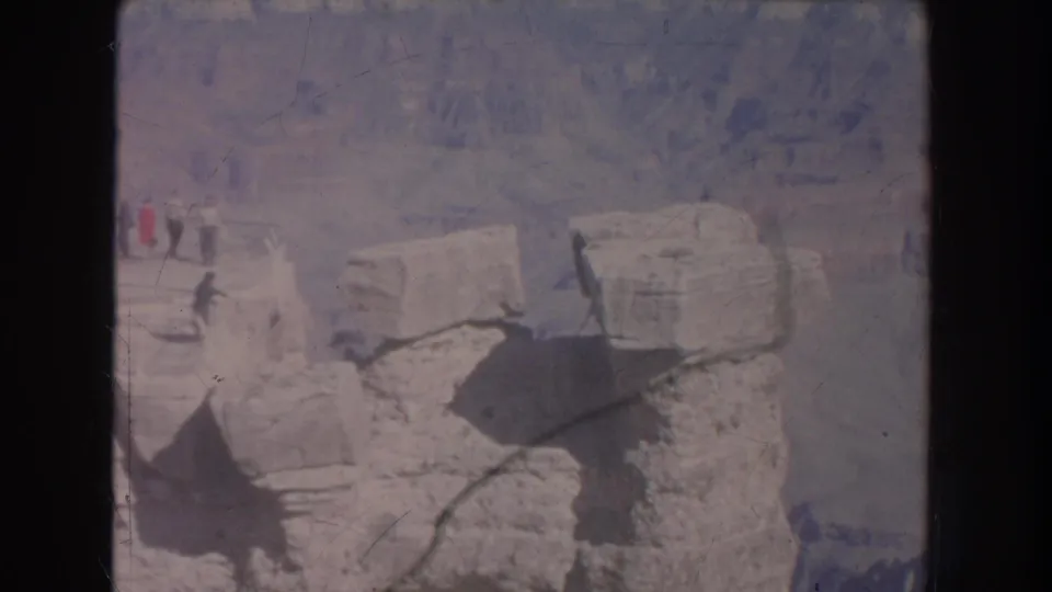 1951 8mm view of a rocky canyon overlook in New Mexico, with visitors partly visible at the left edge.