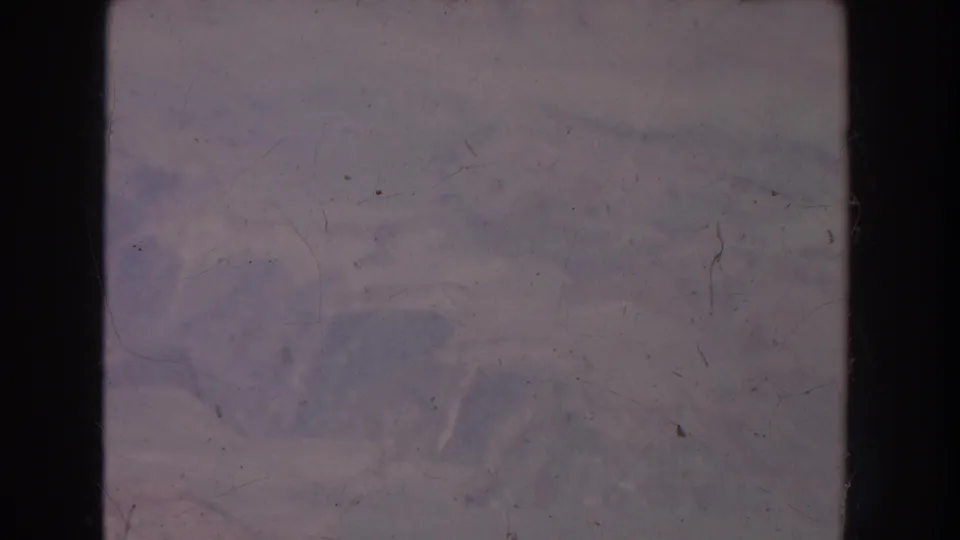 Faded New Mexico canyon landscape from 1951 home-movie footage, with distant rock forms and visible film wear.