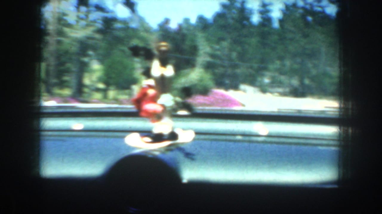 Dashboard figurine in front of a road and landscaped grounds.