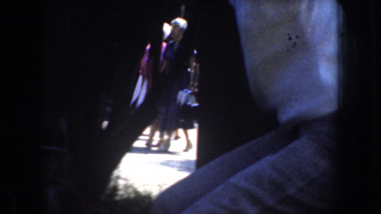 Close view of people in shade with bright sidewalk and figures visible outside.