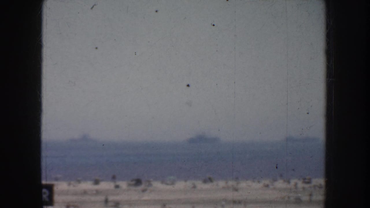 1952 California home-movie view of the ocean horizon with faint ships in the distance, framed by dark vertical edges.