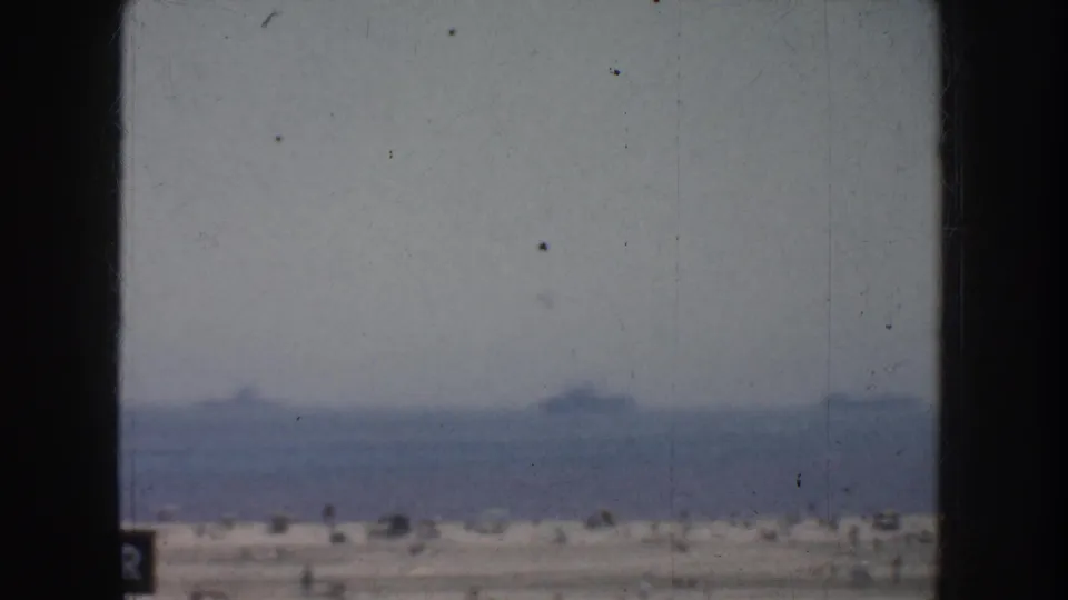 1952 California home-movie view of the ocean horizon with faint ships in the distance, framed by dark vertical edges.