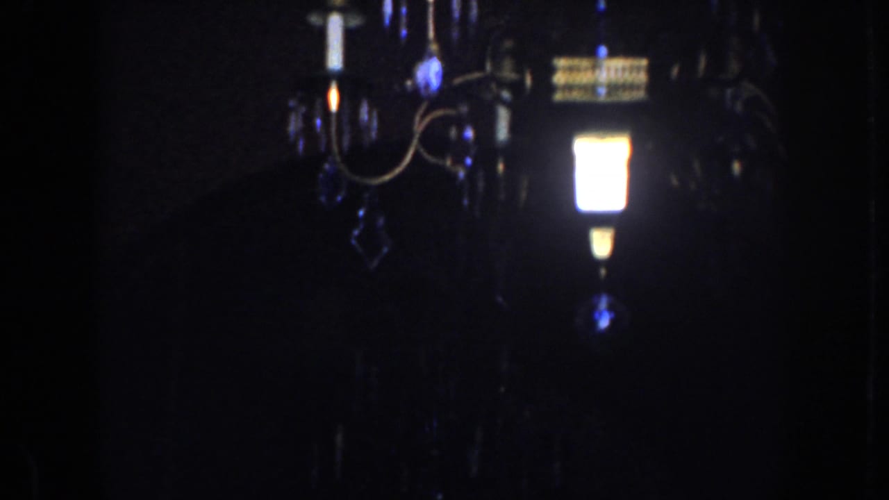 Chandelier partly visible against a very dark room.