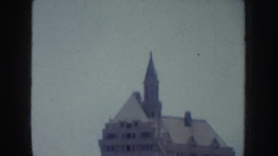 1952 California home-movie view centered on the upper stories and spire of a downtown building.