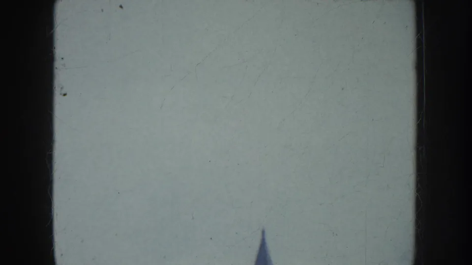 1952 California frame with mostly hazy sky and the pointed top of a city building entering from below.