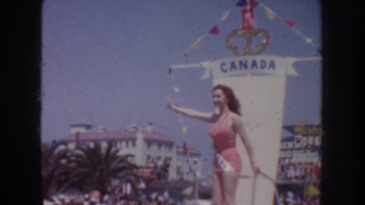 1952 California parade frame showing a contestant on a Canada-labeled float, waving above a crowd and palm-lined street.