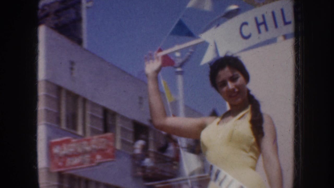 1952 California parade footage shows a woman in a yellow swimsuit and Chile sash waving from a decorated float.
