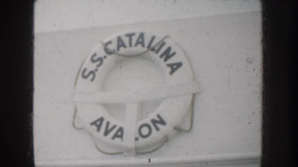 Close view of a life preserver marked "S.S. CATALINA" and partial "AVALON," identifying the ship context in the home-movie clip.