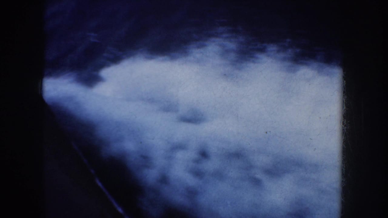 Blurred blue sea surface beside a dark boat structure.