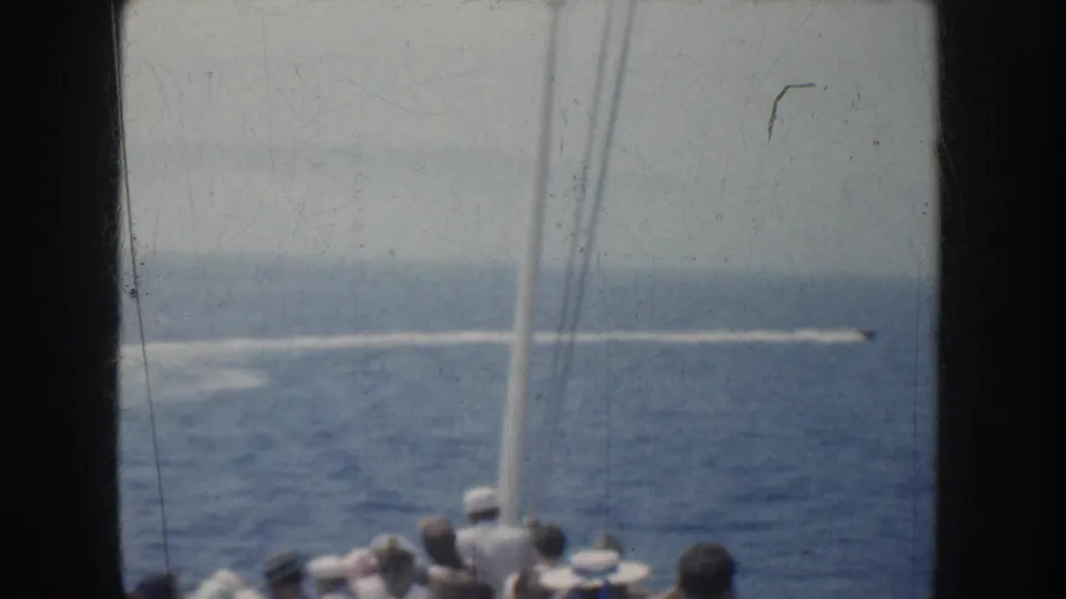 Shipboard 1952 California view of a speedboat wake across blue water, with dark passenger silhouettes and rigging in the foreground.