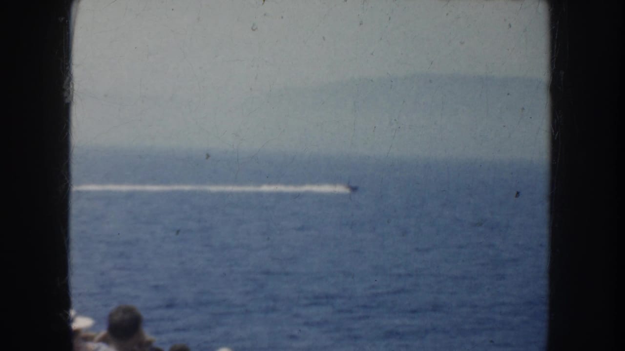 1952 California home-movie frame showing a small speedboat leaving a white wake across open blue water.