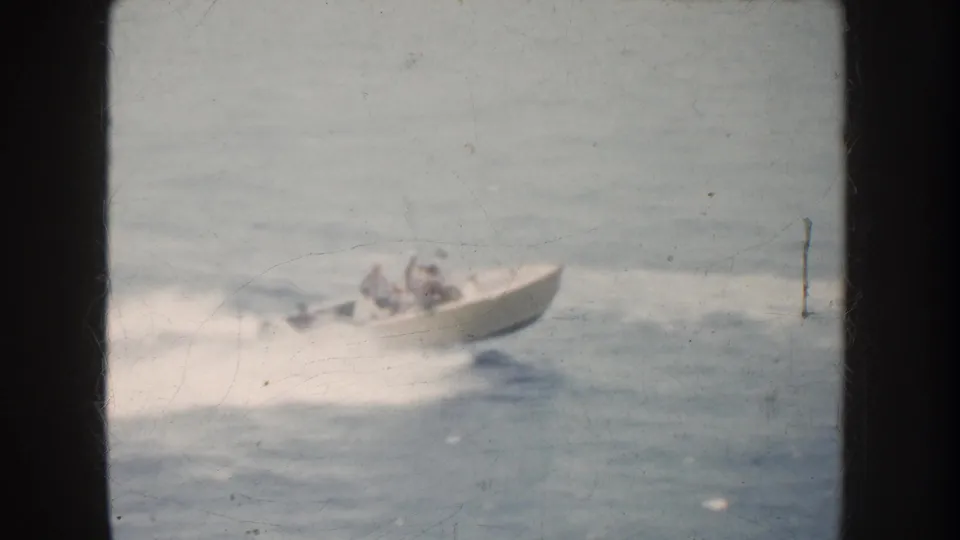 The 1952 California 8mm footage shows a passenger motorboat continuing across open water, framed by dark vertical bars.