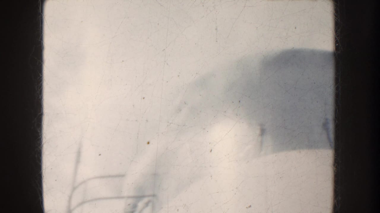 1952 California 8mm frame showing a boat-side view with railing, open water, and hazy mountains beyond.