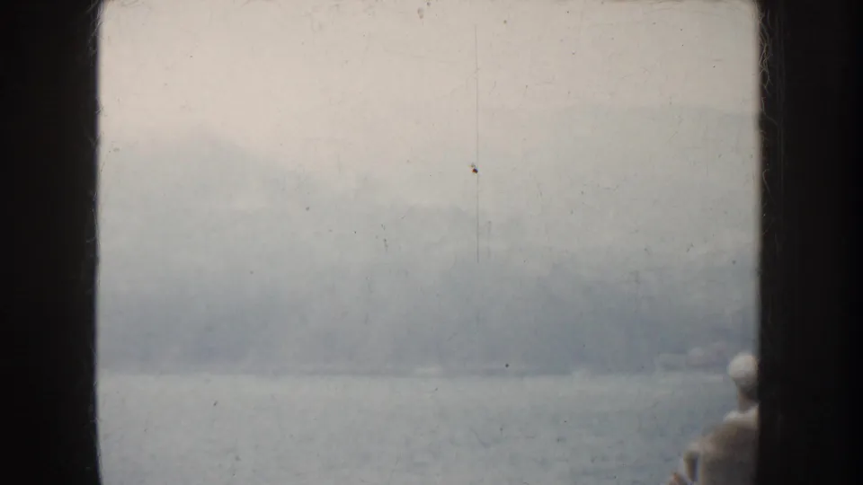 1952 California 8mm view over water toward hazy mountains, with a small indistinct person low in frame.
