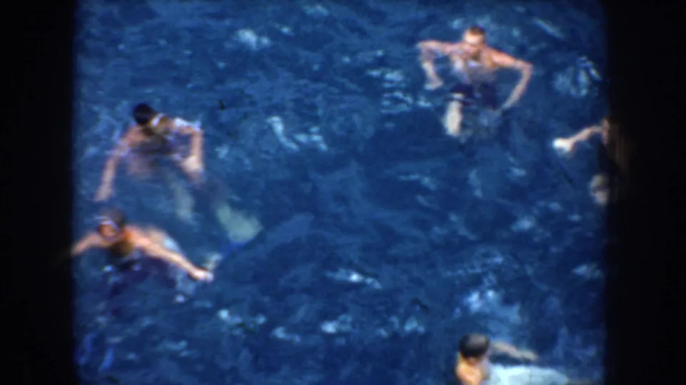 1952 California home-movie view of several swimmers floating and moving through blue ocean water with visible 8mm grain.