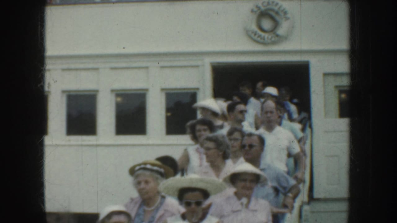 Crowd in summer clothing leaving a white passenger doorway.