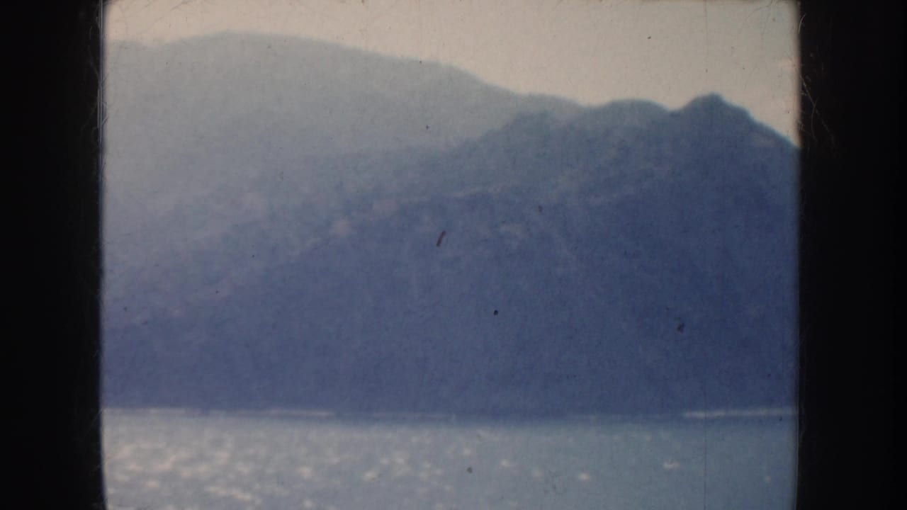 1952 California 8mm home-movie view of hazy mountains beyond bright water, framed by dark film edges.
