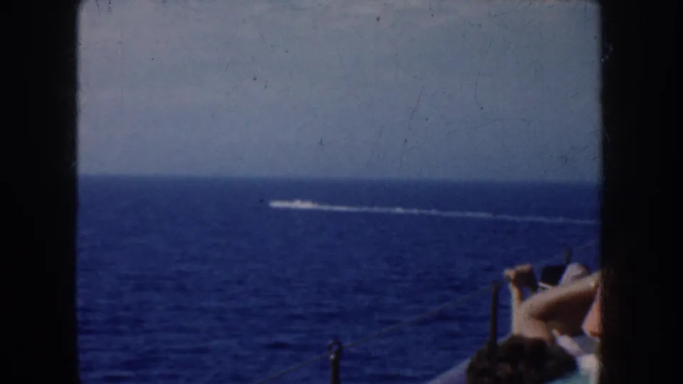 1952 California coastal travel footage showing open ocean, a small speedboat wake, and partial passengers near the frame edge.