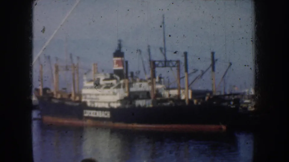 1952 California harbor frame showing the Luckenbach cargo ship with dark hull, white superstructure, cranes and masts.