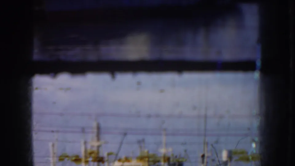 The 1952 California harbor remains visible beyond dark foreground bands, with soft masts and shoreline elements in faded color.