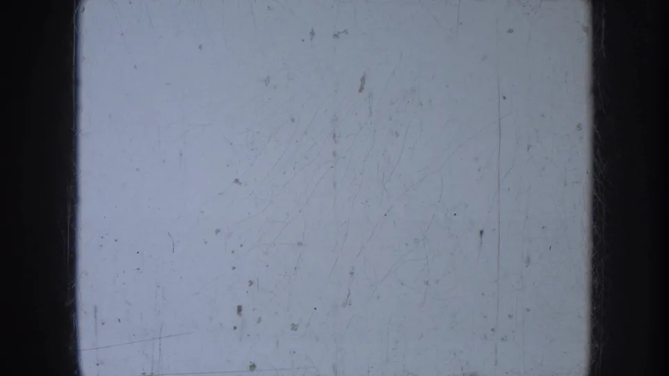 The final frame is largely pale exposed film with visible scratches, dust marks, and dark 8mm gate edges rather than a clear subject.