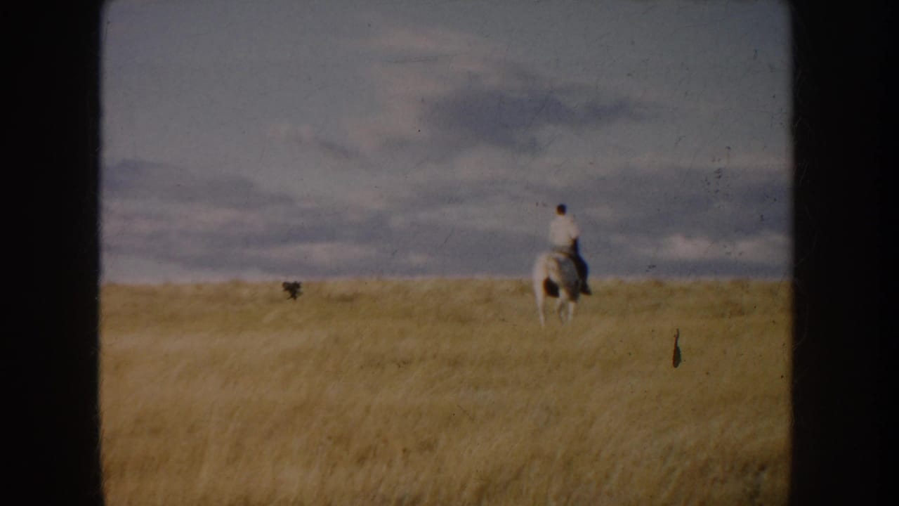 A distant rider on a dark-and-white horse crosses the open South Dakota field in this 1953 8mm frame.