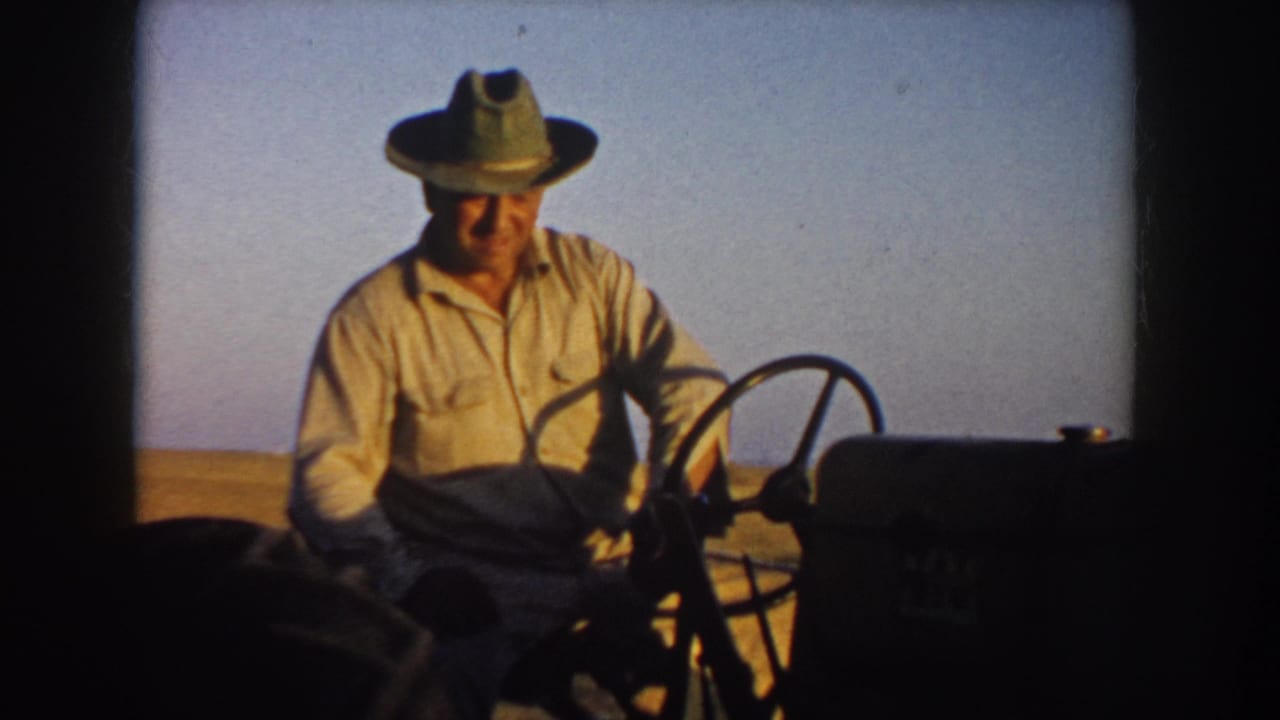 The final frame shows the farmer closer to camera on the tractor, with soft 8mm focus, dark frame edges, and the open field in the background.